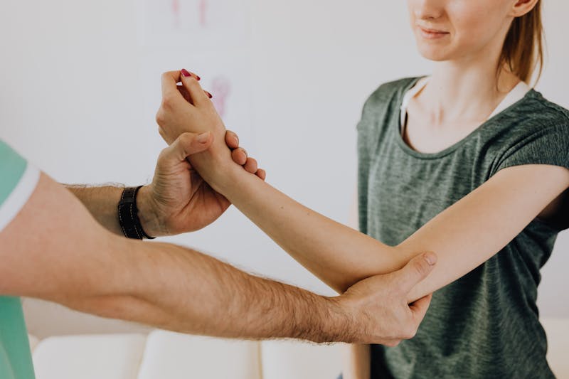 Physiotherapist examining a patient's arm during a consultation