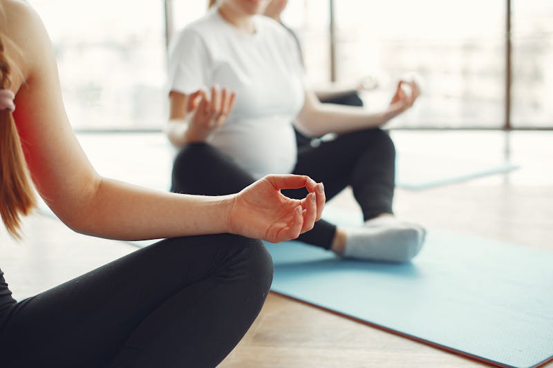 Pregnant women doing yoga and meditation exercises in a fitness studio